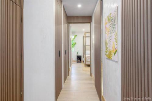 a hallway with white walls and wood floors and a hallway with a hallway at Aloha Moon - A Chic and Dreamy Modern Tropical Hideaway! in Wailea
