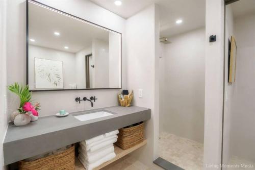 a bathroom with a sink and a mirror at Aloha Moon - A Chic and Dreamy Modern Tropical Hideaway! in Wailea