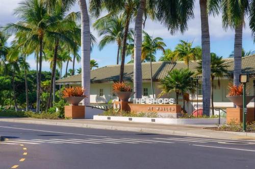 a building with palm trees on the side of a street at Aloha Moon - A Chic and Dreamy Modern Tropical Hideaway! in Wailea