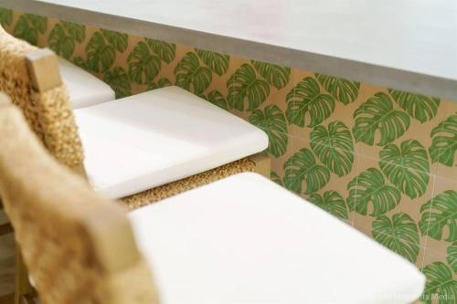 a pair of chairs in a room with a wallpaper at Aloha Moon - A Chic and Dreamy Modern Tropical Hideaway! in Wailea