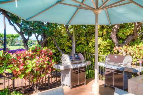 two bbqurgers and an umbrella on a patio at Aloha Moon - A Chic and Dreamy Modern Tropical Hideaway! in Wailea