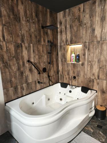 a white bath tub in a bathroom with wooden walls at הפנינה האנגלית in Ramla