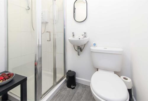a bathroom with a toilet and a sink and a shower at Stylish & Central 2 bedroom apartment - Fast WiFi in Castle Donington