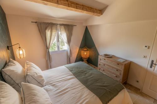 une chambre avec un grand lit et une fenêtre dans l'établissement La Bastide Blanche au coeur des vignes Maison MIP, à Puyloubier