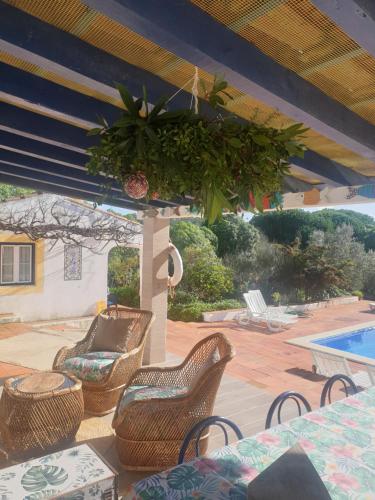 a patio with wicker chairs and a swimming pool at Sondela Self Catering in São Martinho do Porto