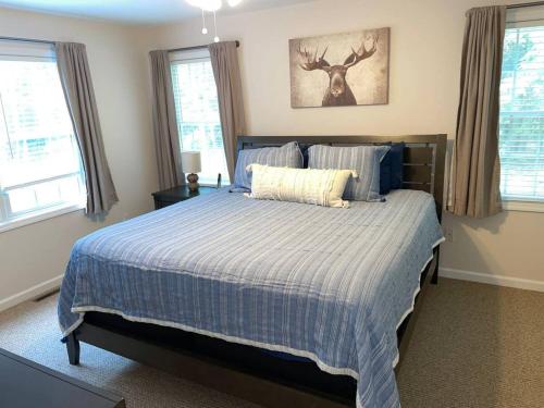 a bedroom with a bed with a blue comforter at Amazing Acorn in Diamond Point