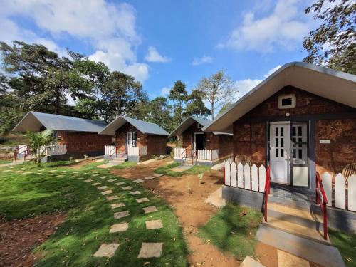 a brick house with a white fence in front of it at The Dandelion - Colonels Jungle Resort in Khānāpur