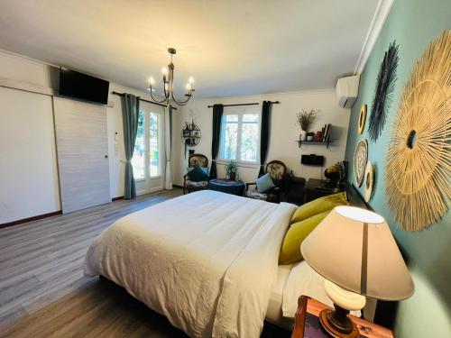 a bedroom with a bed and two children sitting in chairs at La Maison du Chemin des Prairies in Morières-lès-Avignon