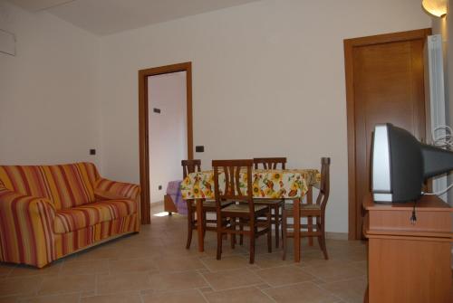 a living room with a table and chairs and a television at Agriturismo Miralago in Scanno