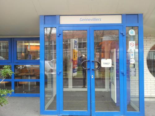 a blue door in front of a store at ibis Budget Gennevilliers Asnieres in Gennevilliers