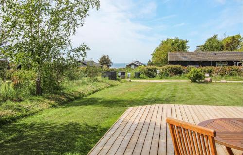 a patio with a wooden table and a lawn at 3 Bedroom Lovely Home In Samsø in Kolby Kås