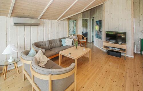 a living room with a couch and a tv and a table at 3 Bedroom Lovely Home In Samsø in Kolby Kås