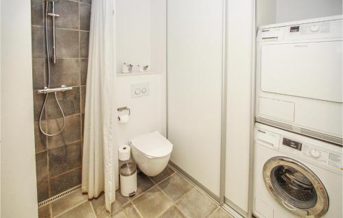 uma casa de banho com um WC e uma máquina de lavar roupa em Lovely Home In Sams With Wifi em Nordby