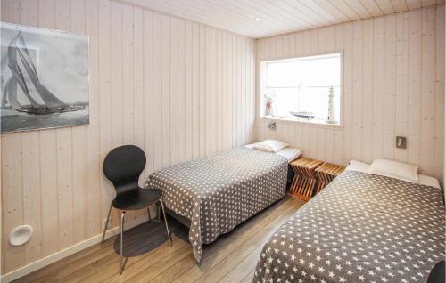 um quarto com duas camas e uma cadeira em Lovely Home In Sams With Wifi em Nordby