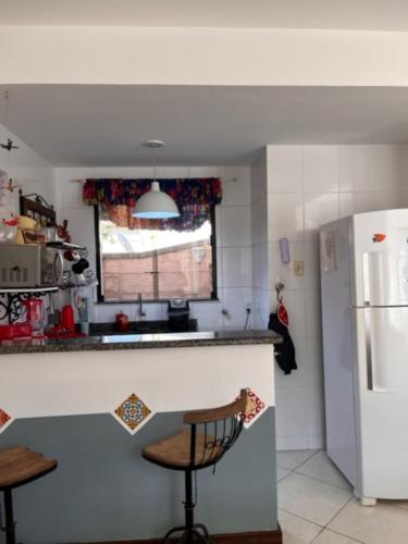 eine Küche mit einem weißen Kühlschrank und einer Theke in der Unterkunft Para-ti e para-mim! Para todos nós! in Paraty
