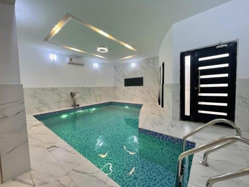 Al Raka的住宿－شاليه الروح AlRooh Chalet，一间位于客房内的带游泳池的浴室