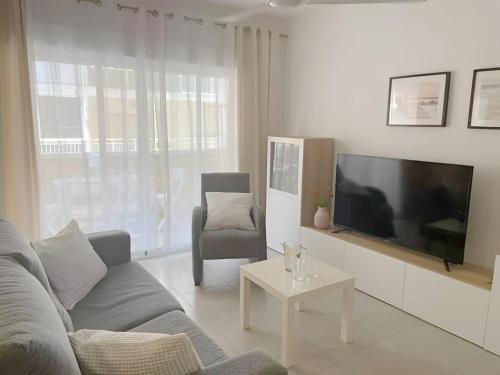 a living room with a couch and a flat screen tv at C. del Mar - de Luxe apartament Centrum Torrevieja in Torrevieja