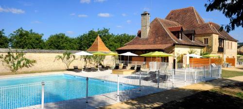une maison avec une piscine à côté d'un bâtiment dans l'établissement Le Clos des Rives, à Saint-Vincent-de-Cosse