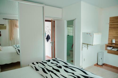 a zebra print bedroom with a bed and a refrigerator at Casa de Campo com Piscina e lazer em Cascavel PR in Cascavel