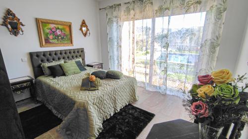 a bedroom with a bed and a large window at Quinta dos Padrinhos - Suites in the Heart of the Douro in Lamego