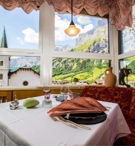 a table with a view of a mountain view from a window at Hotel Restaurant Escher in Leukerbad
