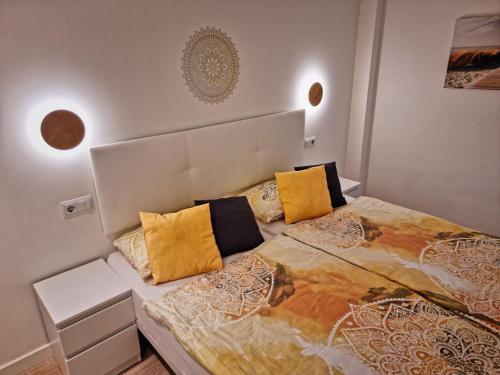 a bedroom with a large bed with yellow pillows at Cozy apartment with a fantastic sea view in Cala Millor