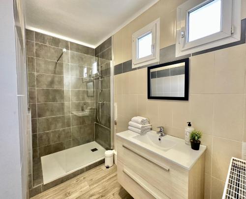 ein Badezimmer mit einem Waschbecken, einer Dusche und einer Badewanne in der Unterkunft DESIGN MODERNE SPACIEUX - Familial in Mont-de-Marsan