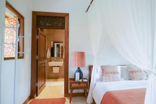 a bedroom with a bed with a white canopy at Gayatri in Ubud
