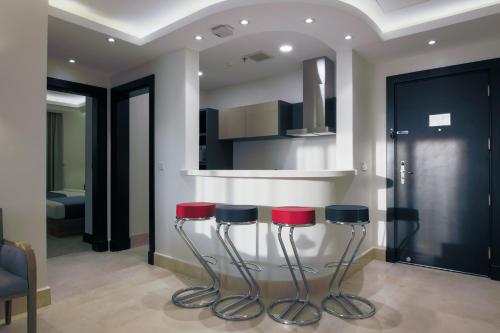 a kitchen with two stools and a counter at The Proud Hotel Al Khobar in Al Khobar