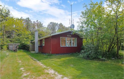 a red cabin in the middle of a yard at Cozy Home In Samsø With Kitchen in Kolby Kås