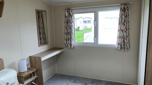 Habitación con ventana con cortinas y mesa. en Oyster Etchingham SEAVIEW, en Whitstable