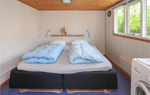 a bed in a small room with two pillows on it at Cozy Home In Samsø With Kitchen in Kolby Kås