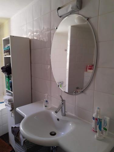 y baño con lavabo blanco y espejo. en Loft in Borgloon en Borgloon