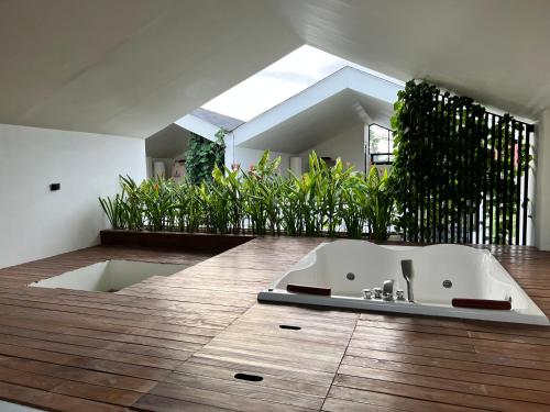 a bathroom with a bath tub on a wooden floor at EL Suites Canggu in Canggu