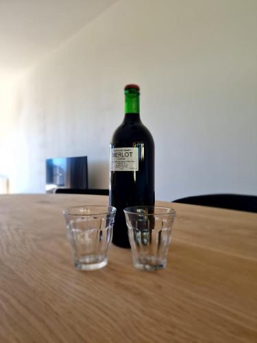 a bottle of wine and two glasses on a table at Nest Lodge in Weissbriach