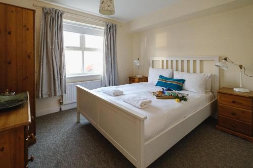 a bedroom with a large white bed with a window at 1 Coastguard Court in Aldeburgh