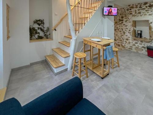 salon ze stołem i schodami w obiekcie Maison de Caractère rénovée avec gout pour 2 personnes w mieście Saint-Geniès-de-Fontedit