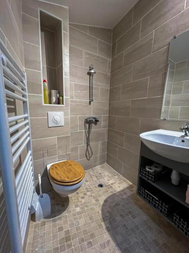 La salle de bains est pourvue de toilettes en bois et d'un lavabo. dans l'établissement Maison de Caractère rénovée avec gout pour 2 personnes, à Saint-Geniès-de-Fontedit
