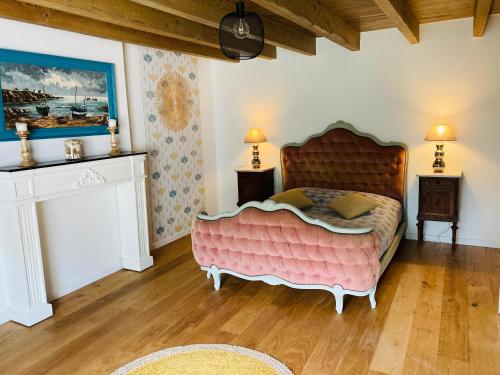 - une chambre avec un grand lit rose dans l'établissement Magnifique Maison Familiale, à Quistinic