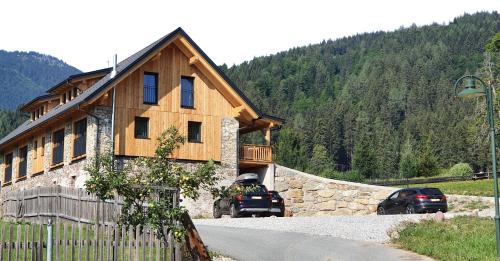 ein Haus mit einem davor geparkt in der Unterkunft Weißbriach Lodge in Weissbriach