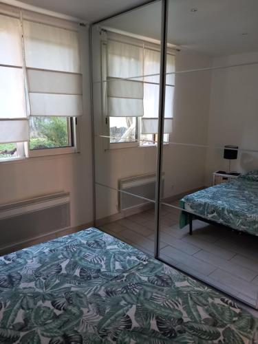 une chambre avec un lit et un miroir dans l'établissement Petit chalet en bois, à Reynès