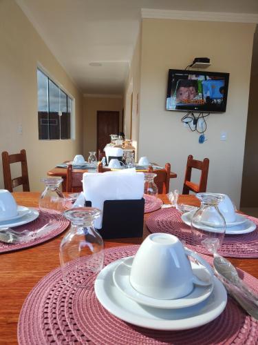 聖米格爾－杜戈斯托蘇的住宿－Pousada Brilho do Sol，餐桌,盘子和盘子