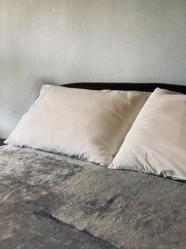 a bed with two white pillows on it at Little Eden Guesthouse in Pang Mapha