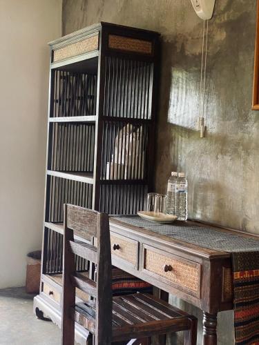 a wooden table and a book shelf in a room at Little Eden Guesthouse in Pang Mapha