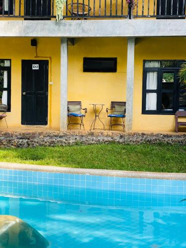 a house with a swimming pool in front of a building at Little Eden Guesthouse in Pang Mapha