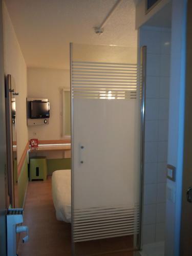 a room with a bed and a sliding glass door at ibis Budget Gennevilliers Asnieres in Gennevilliers