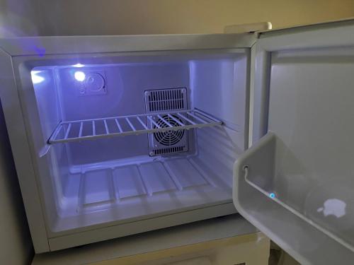 an empty refrigerator with its door open and its lights on at La Romance et la Romanesque in Berville-sur-Mer