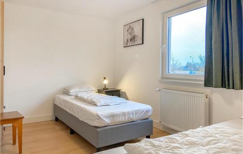1 dormitorio con 2 camas y ventana en Kavel 12, en Den Oever