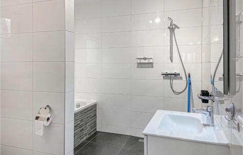 a white bathroom with a shower and a sink at Kavel 12 in Den Oever