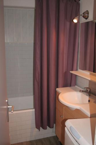 une salle de bain avec un lavabo et un rideau de douche dans l'établissement Appartement Courchevel 1650 pied des pistes, à Courchevel
